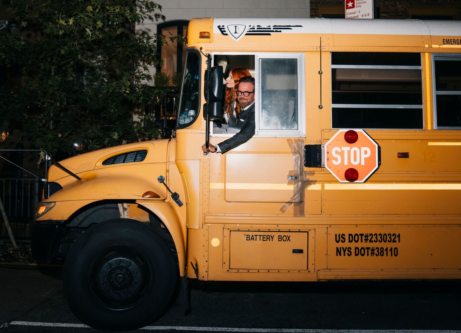 A yellow school bus with the STOP sign on its side parked on a city street.