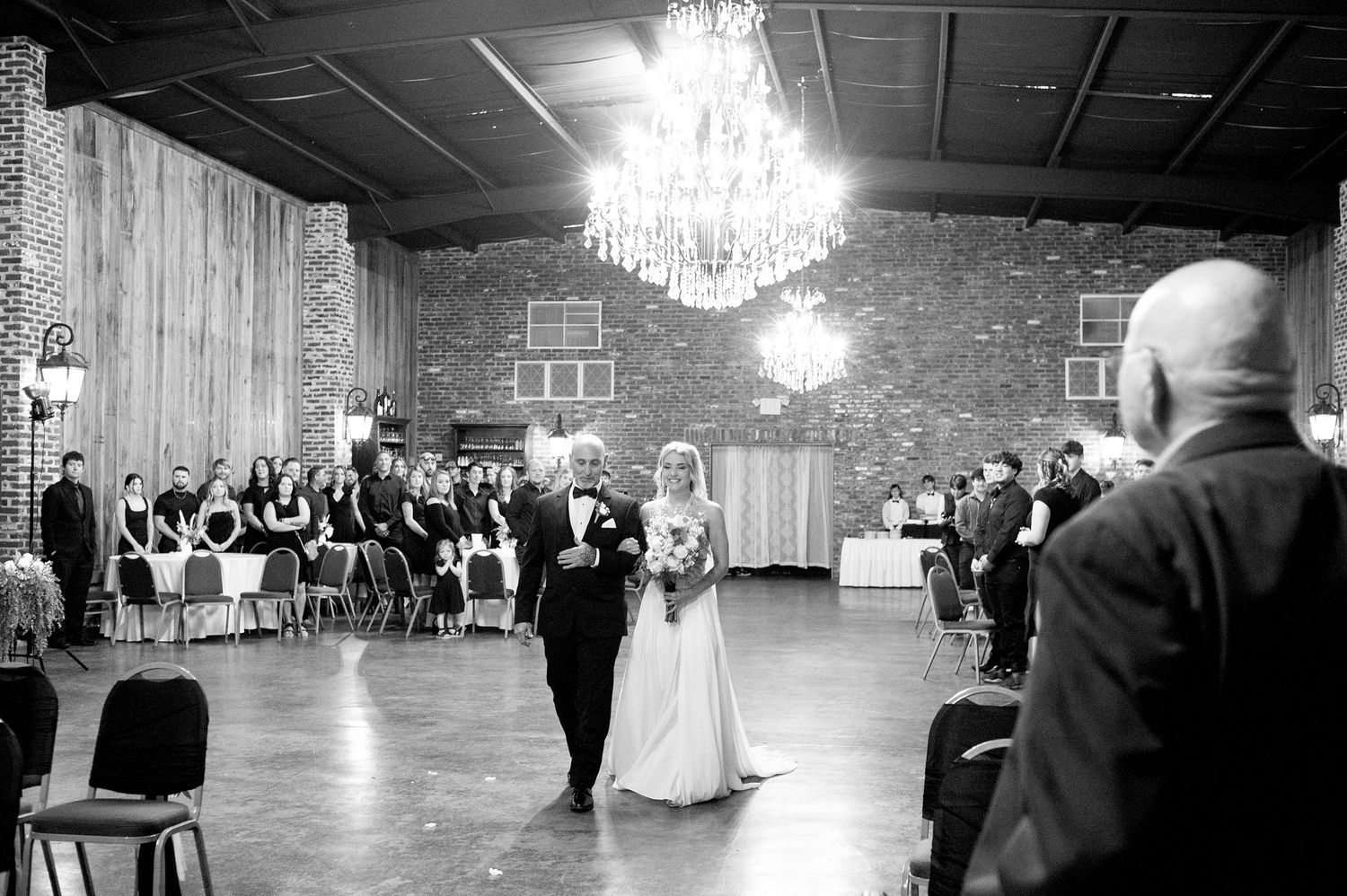 Wide angle shots of wedding ceremony in elegant ballroom with chandeliers.