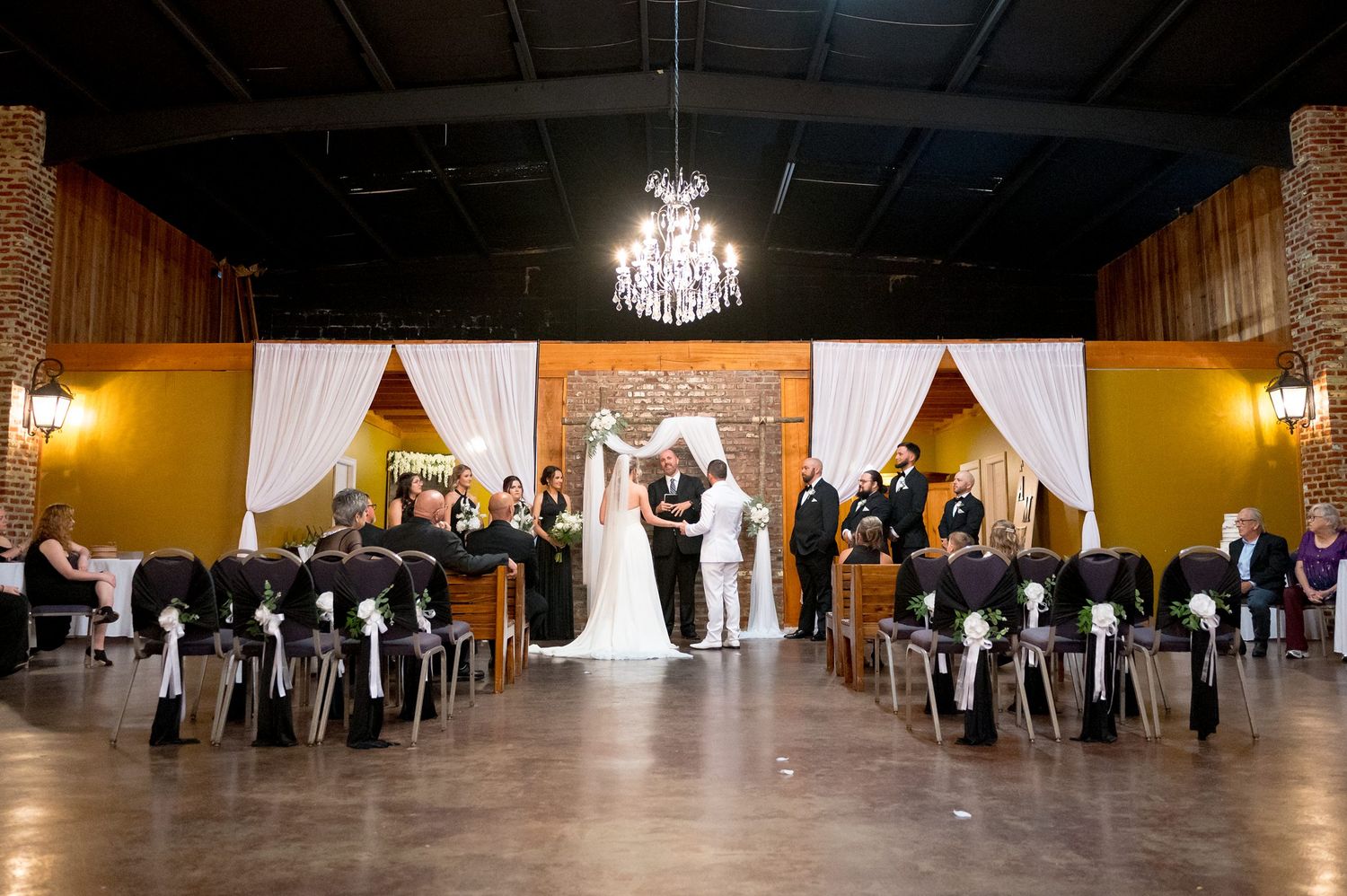 Panoramic views of wedding reception setup in rustic venue with dramatic lighting.
