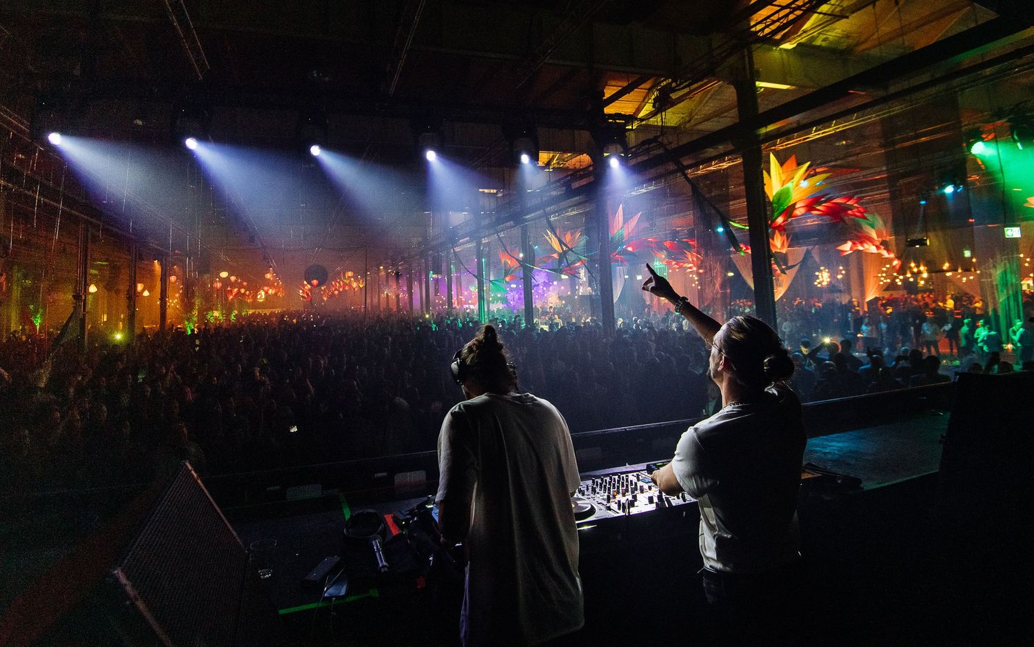 Wide concert venue with dramatic lighting and crowd silhouettes in foreground.