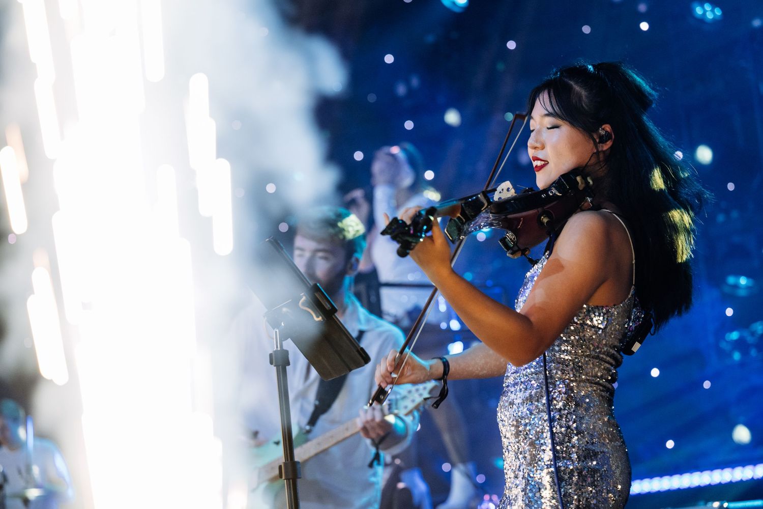 Performance stage with dramatic blue lighting and special effects.