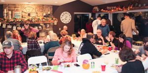 Crowded restaurant dining room filled with people seated at tables during a busy dinner service.