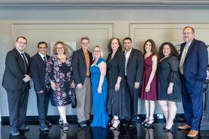 Professional group of business people standing together in a hallway showing workplace collaboration and teamwork.