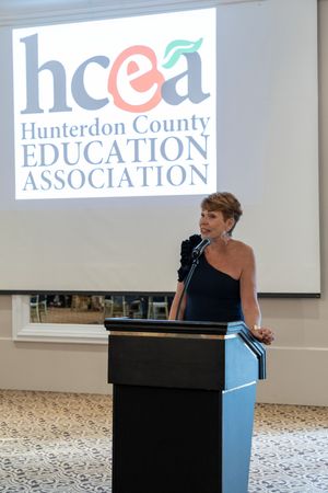 A presentation setup with podiums and projector screens displaying the Hunterdon County Education Association logo.