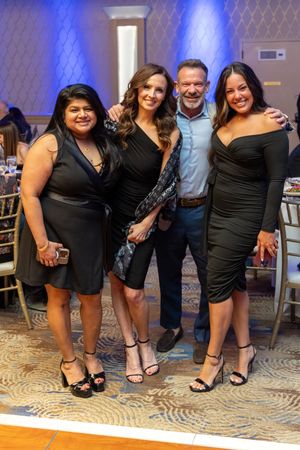 Four guests smile together at the Alternatives Inc. Dignity Gala held at The Marigold ballroom.