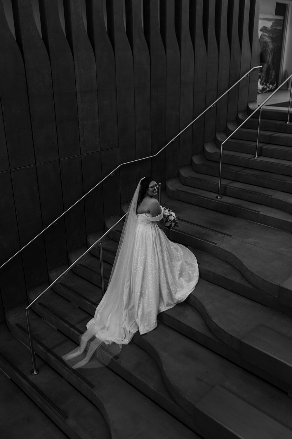 Artistic black and white photo sequence showing a figure in white dress falling down a staircase in dramatic motion.