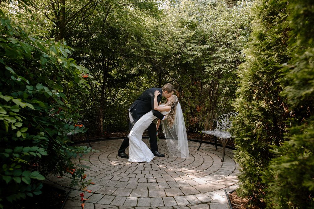 A romantic garden wedding photoshoot with a stone path and lush greenery backdrop.