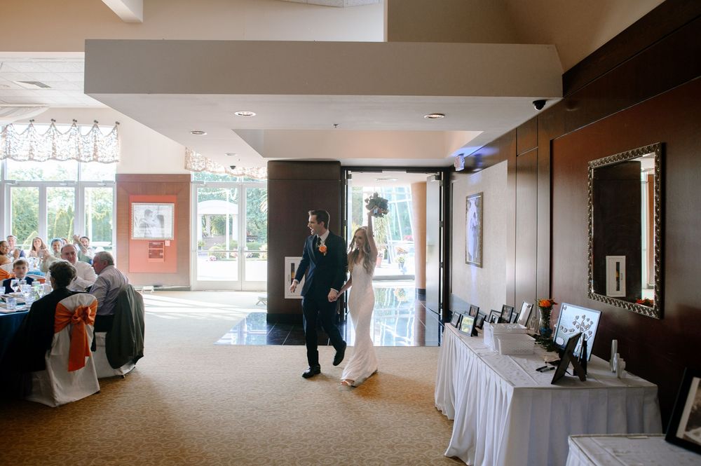 Large empty banquet hall being set up with white drapes and decorations.