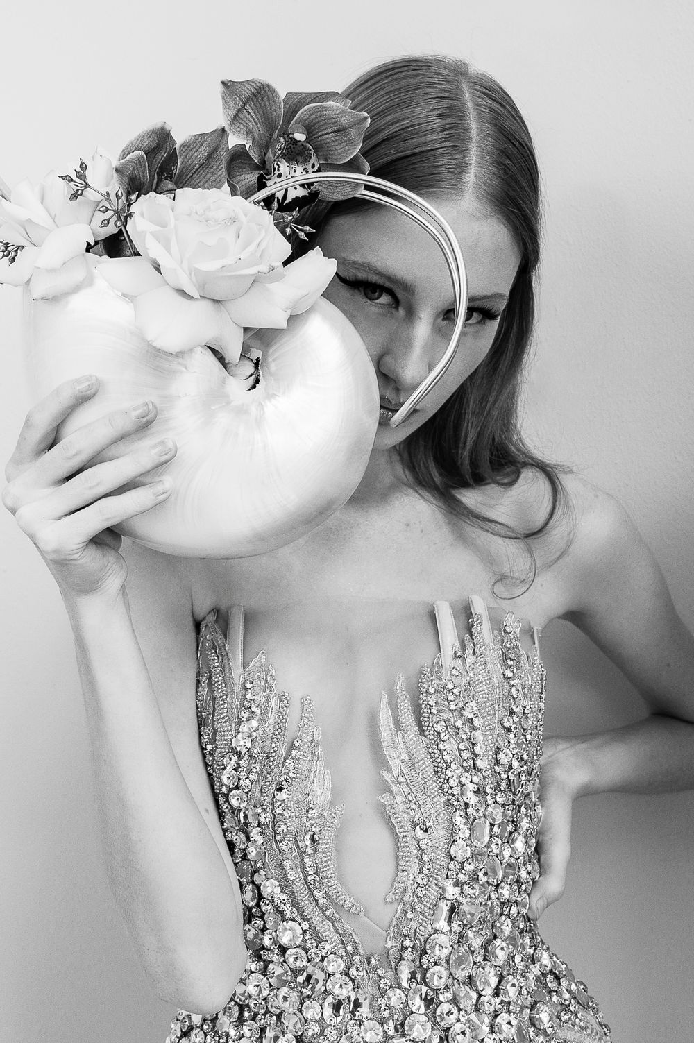 Black and white artistic portrait featuring a crystal-embellished gown and floral elements.