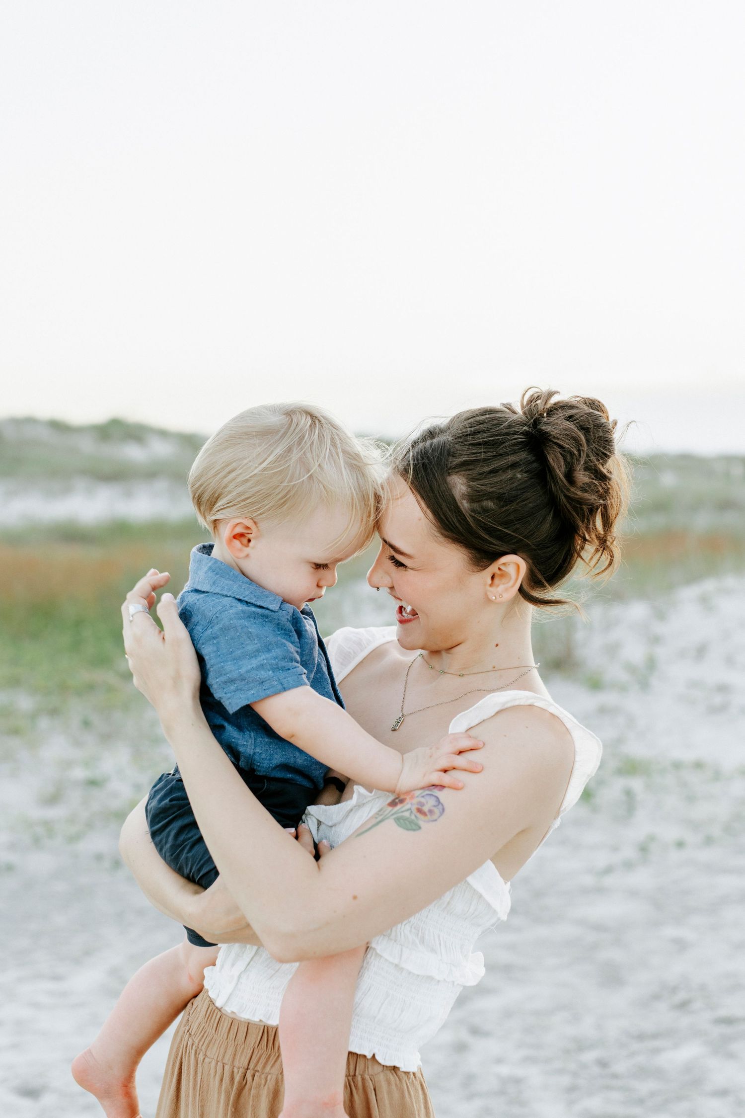 Sweet candid moments of parent and toddler sharing tender interactions on a misty beach.