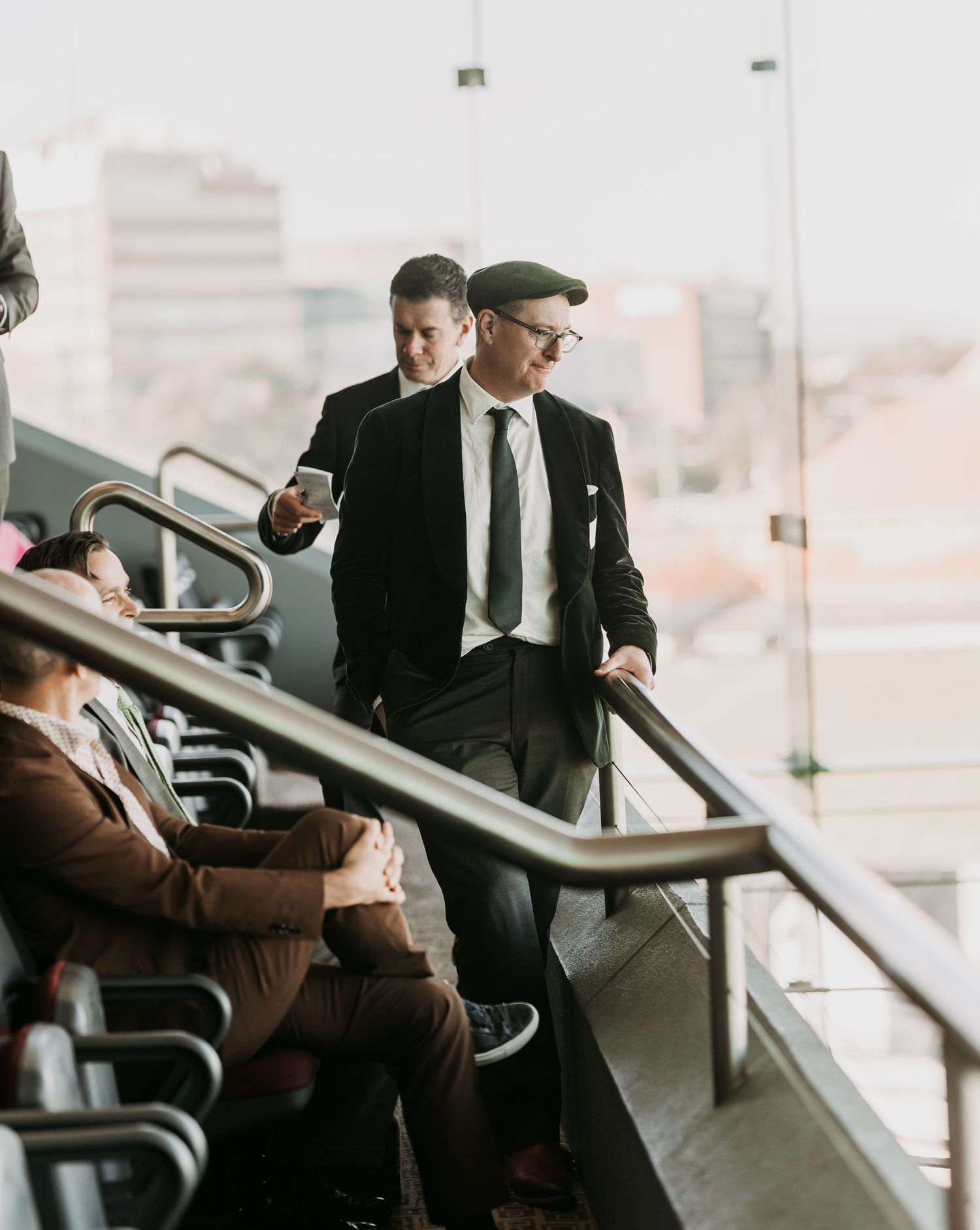 Business professionals engaged in conversation while seated in a waiting area with modern furniture and natural lighting.