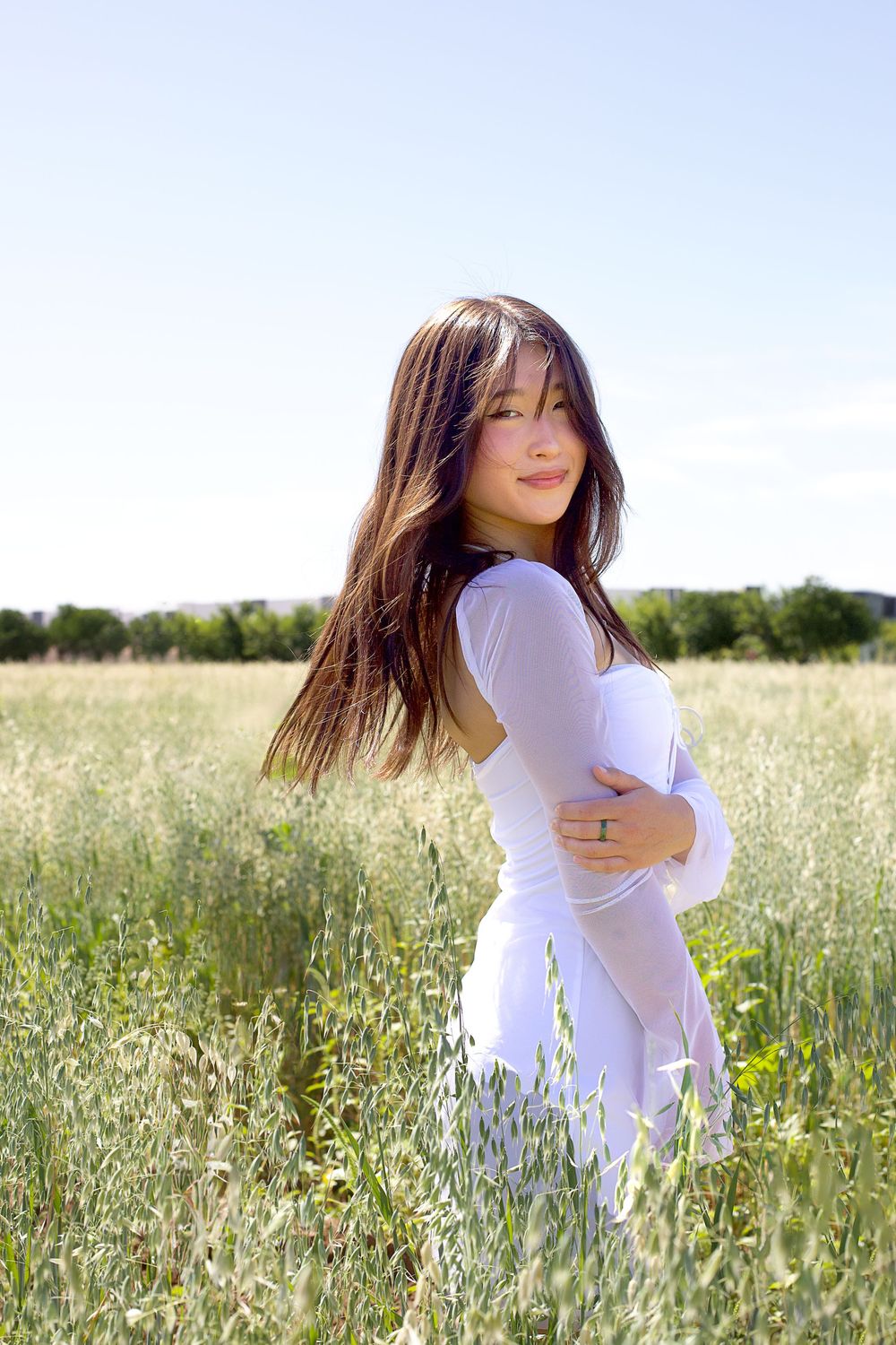 Summer portrait session in a wildflower meadow with tall grass and natural lighting.
