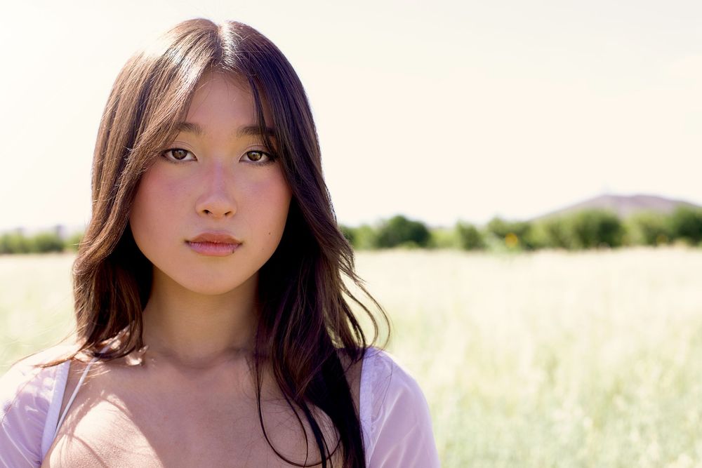 Dreamy outdoor portraits in a sun-lit field with soft natural lighting.