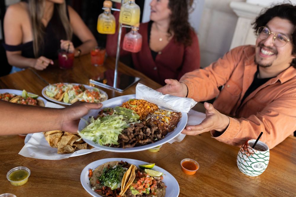 Group enjoying Mexican food and drinks at a casual restaurant gathering.