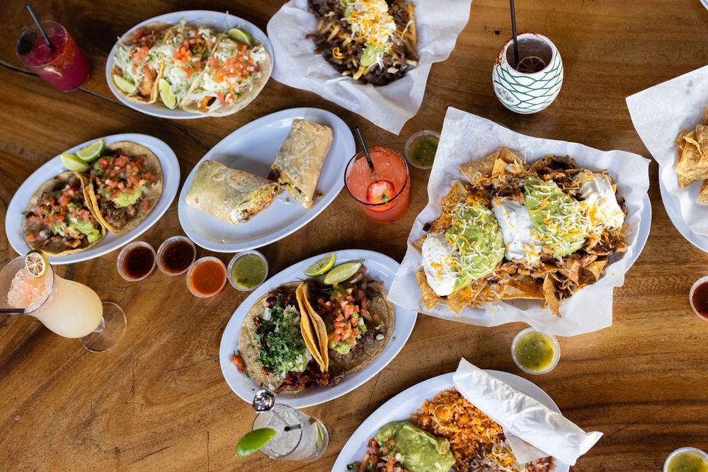 Overhead view of restaurant table filled with various colorful dishes and plates.