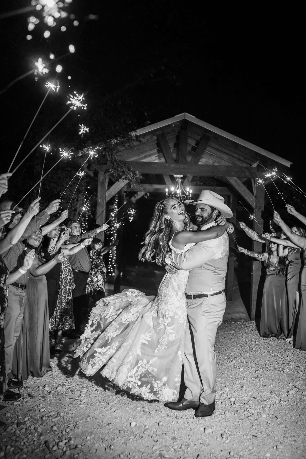Bride and groom kissing during a romantic sparkler send-off at Whispering Oaks wedding venue