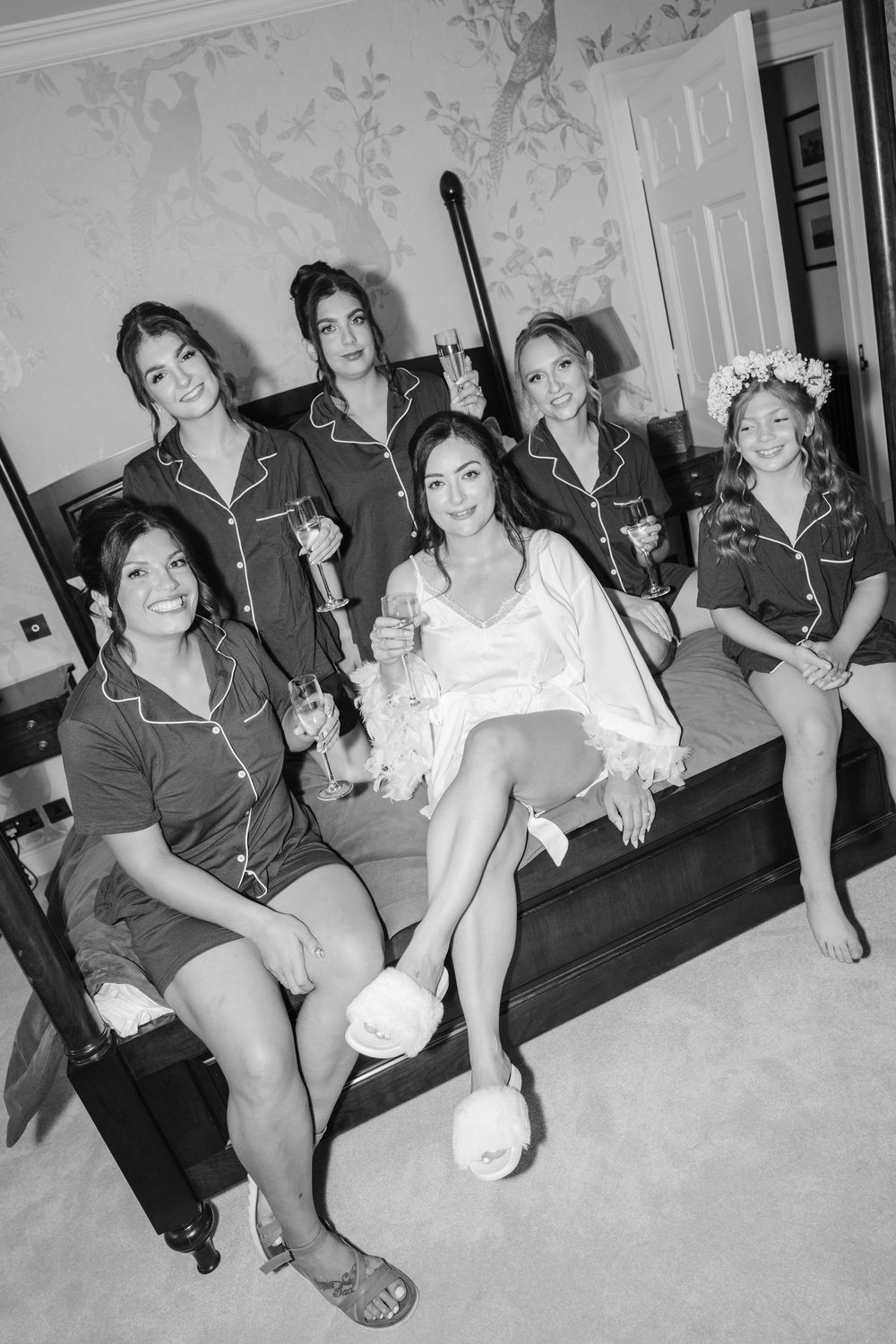 Black and white party scene showing people sitting together and enjoying themselves with drinks and smiles in candid shots.
