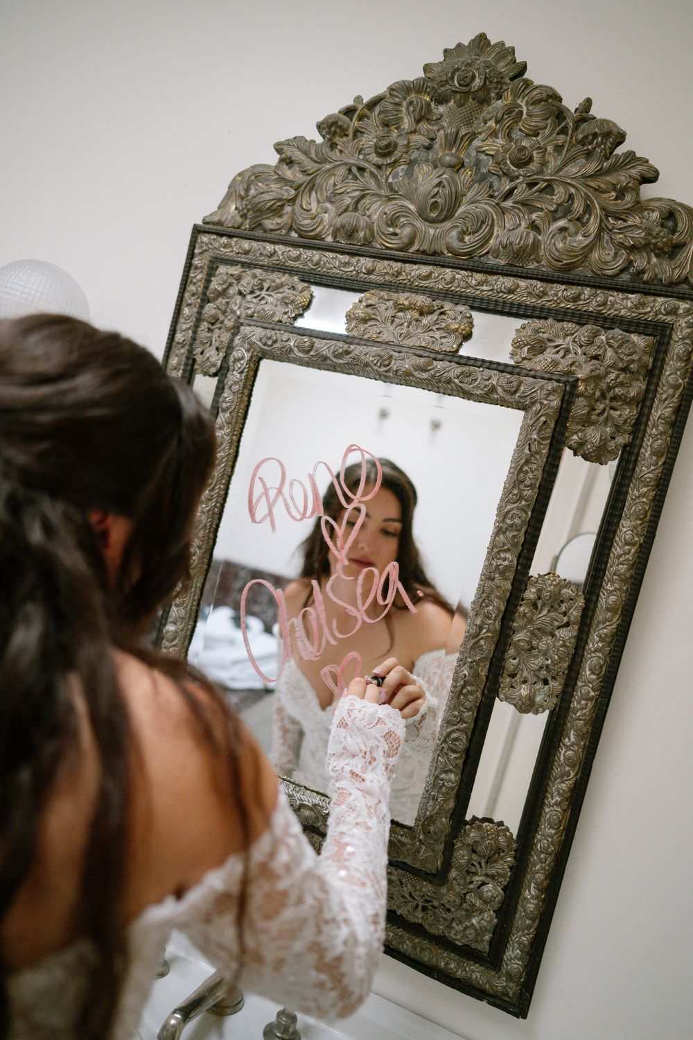 A sequence of reflections in an ornate vintage mirror showing someone adjusting bridal attire.