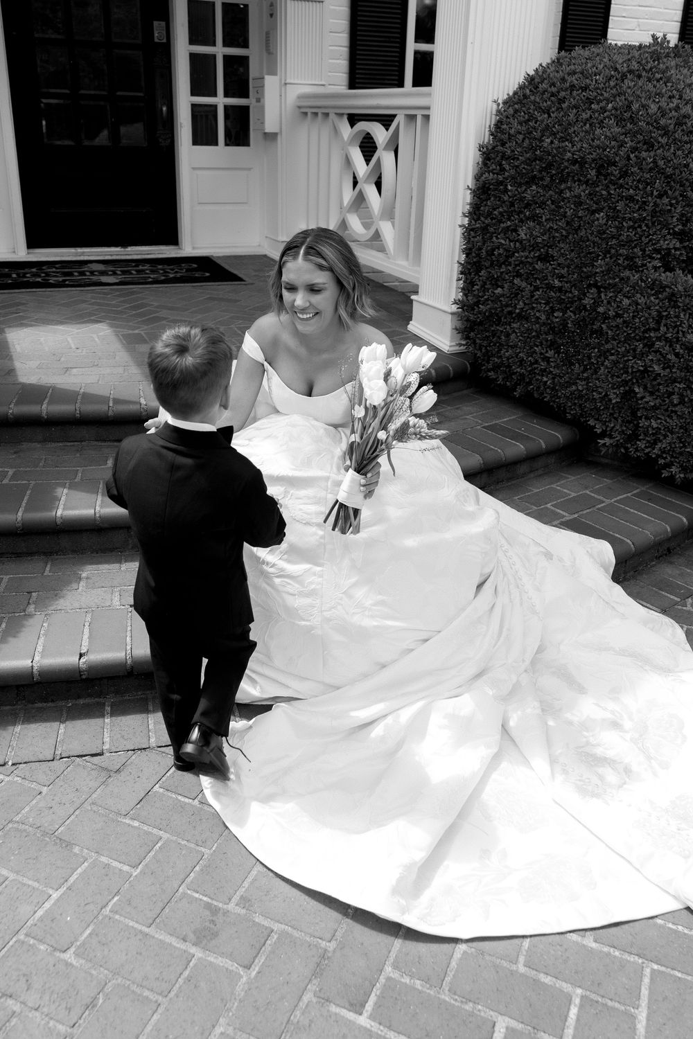 A series of black and white photos showing children in formal wedding attire playing on stone pavers.