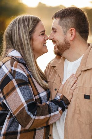 A romantic couple wrapped in a plaid blanket share tender moments at sunset in a series of intimate photos.