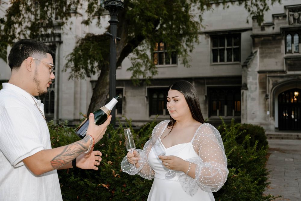Couple celebrates special moment in an elegant outdoor setting with champagne.