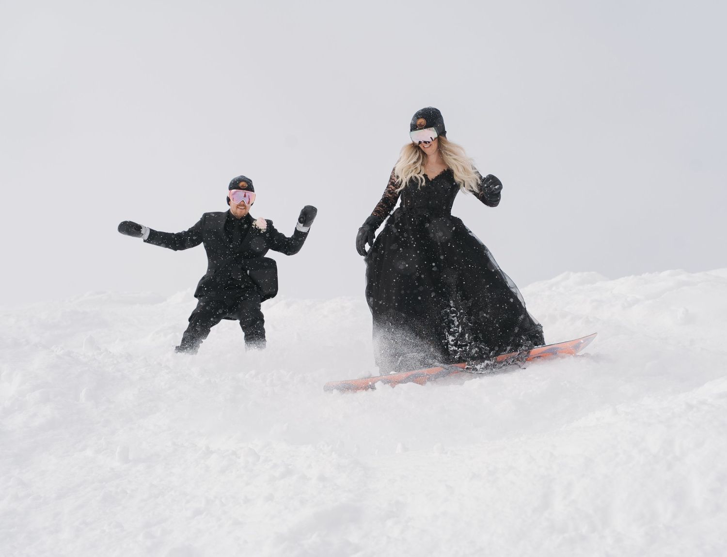 People having fun sledding down a snowy hill in winter as they slide and tumble through the white powder.