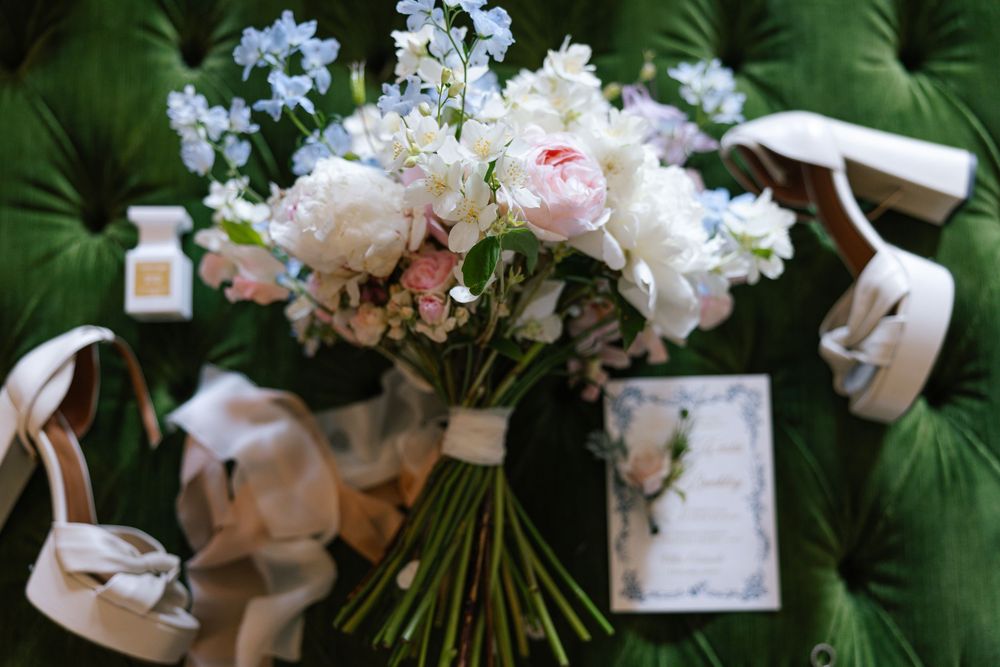 A collection of pink and white floral wedding bouquets arranged with greenery against a dark green background.