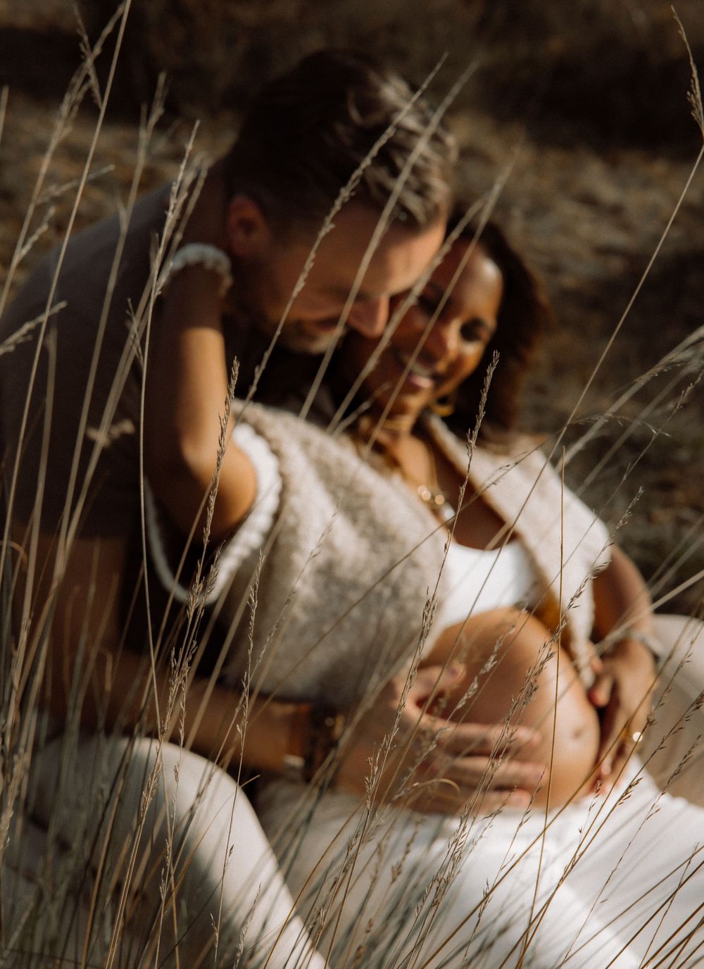 Intimate maternity photo series with soft lighting and natural textures.