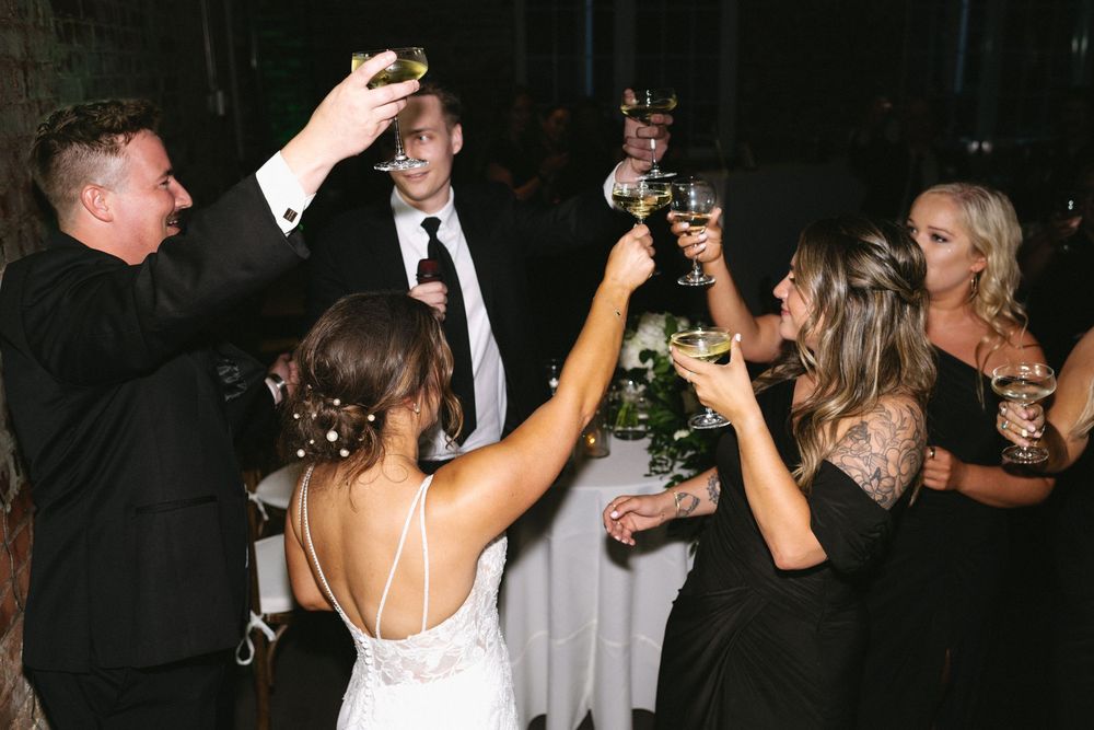 Dark reception venue with dancing guests and party atmosphere.