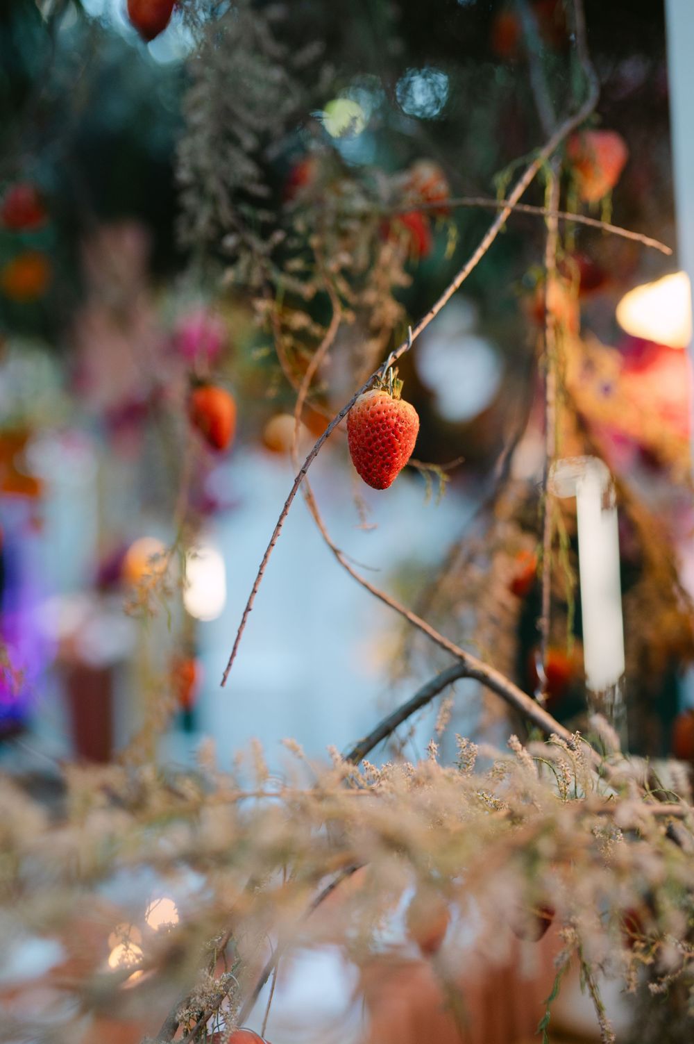 Delicate strawberries and twinkle lights create a romantic garden party atmosphere at dusk.