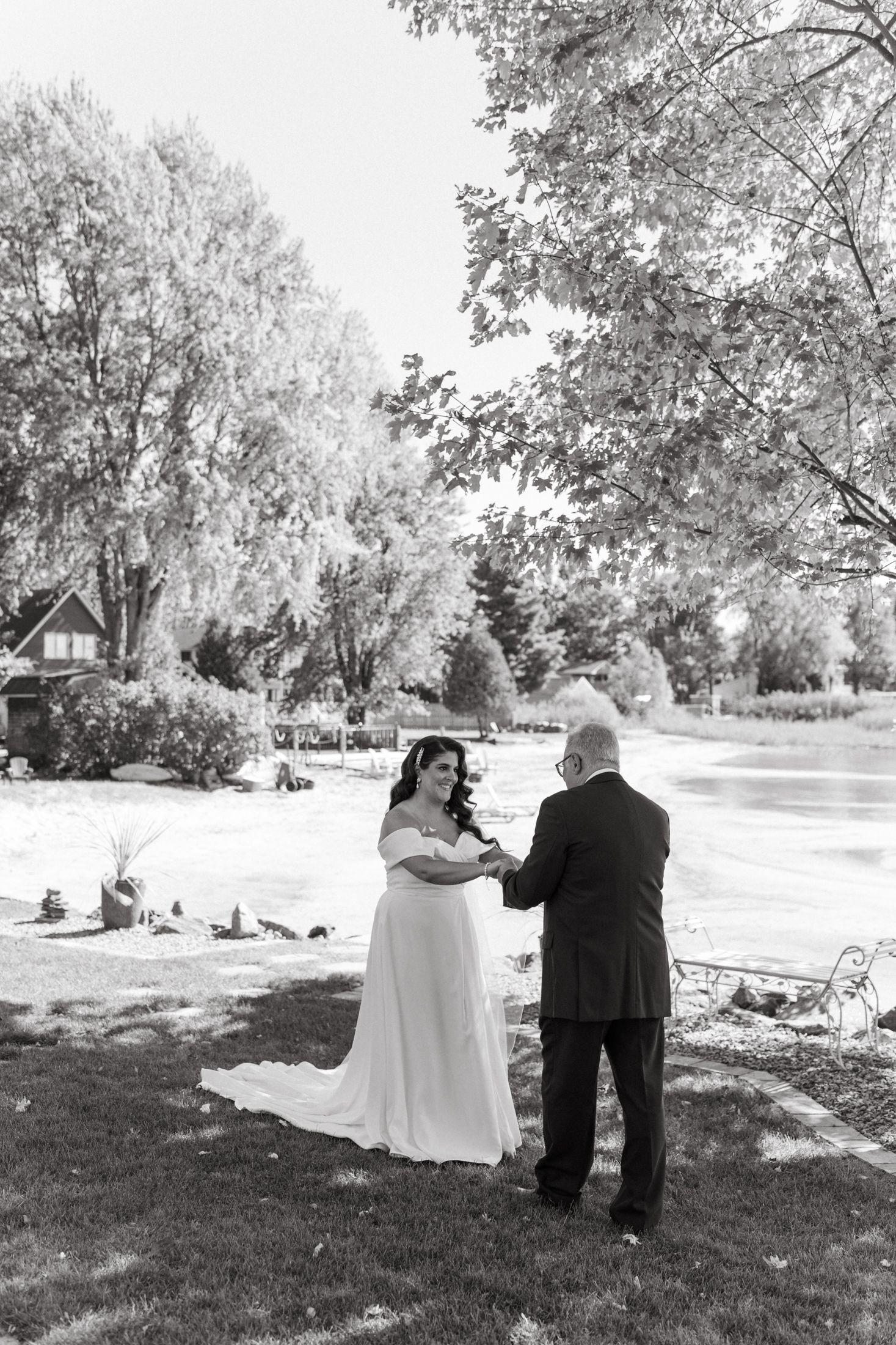 Black and white photo series captures a couple walking together through a scenic park landscape.