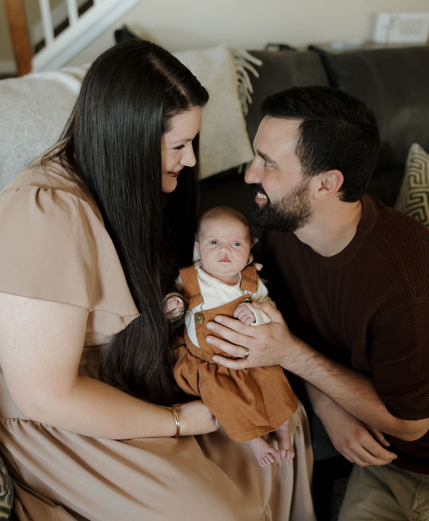 A couple shares tender moments with their newborn baby in a series of intimate black and white photographs.