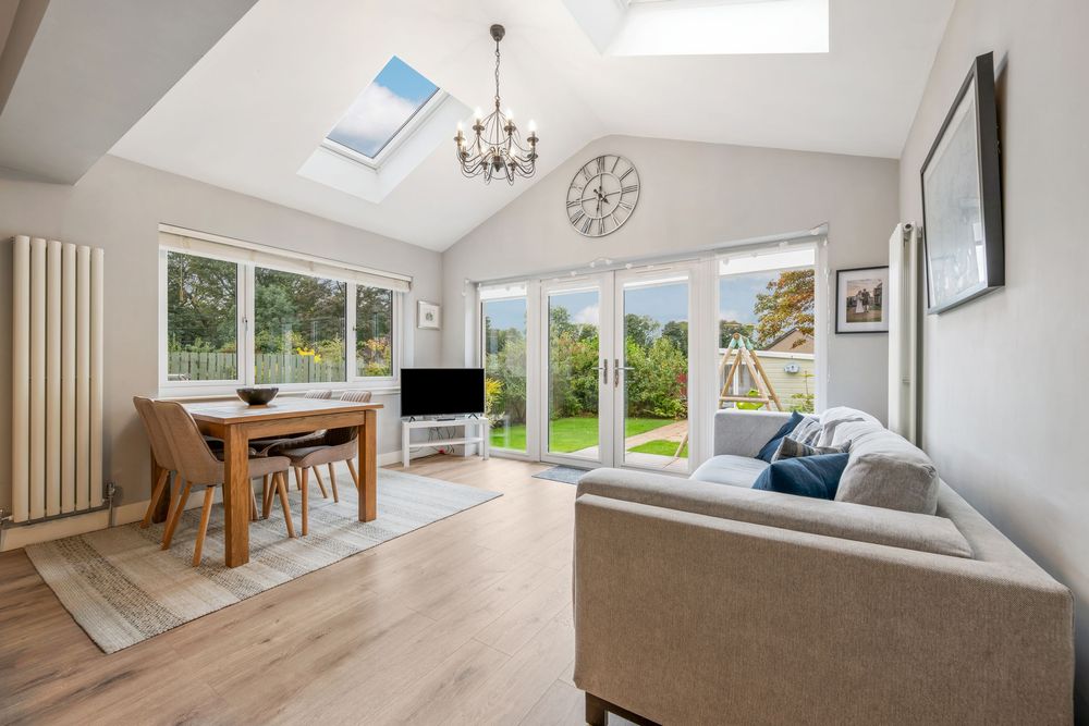 Bright open concept living space with skylights and white walls.