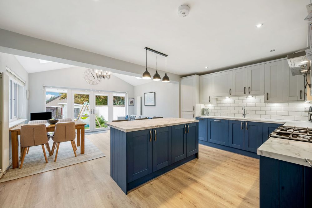 Modern white kitchen with navy blue cabinets and sleek finishes.