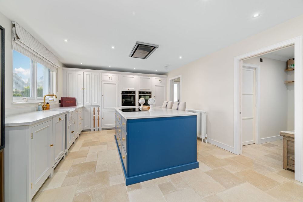 Contemporary open plan living area with navy blue kitchen cabinets.