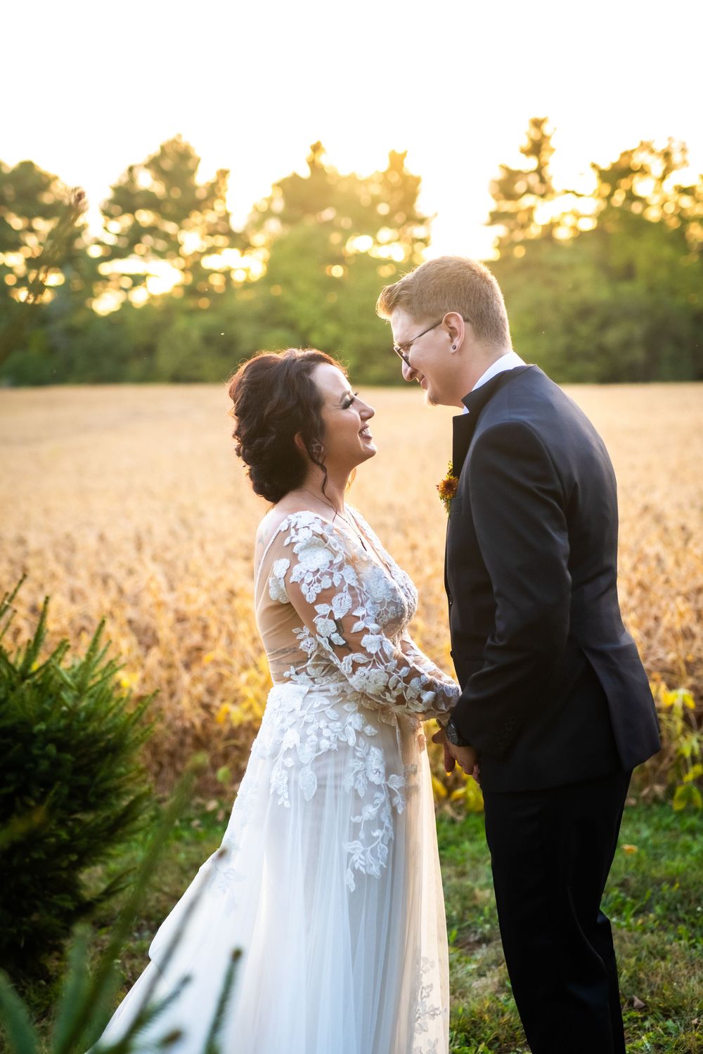 Golden hour wedding portraits in a field showing intimate moments between newlyweds.