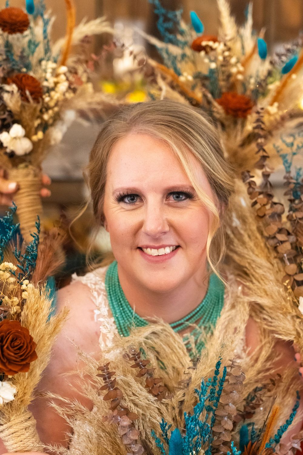 Wedding portrait with turquoise and autumn-themed floral decorations.