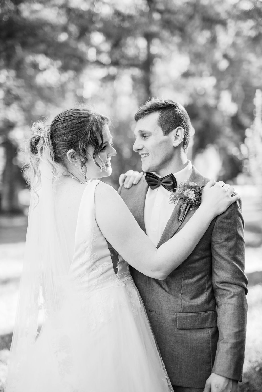 Black and white photo series of a romantic wedding couple sharing intimate moments in a garden setting.