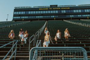 Group photo session on stadium bleachers during golden hour.
