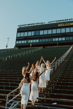 Group ascending stadium bleachers at sunset with Welcome sign visible above.