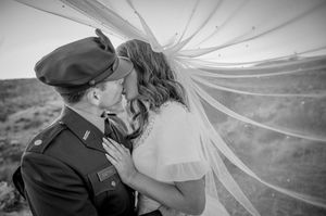 Romantic black and white wedding portraits with flowing veil against mountain backdrop.