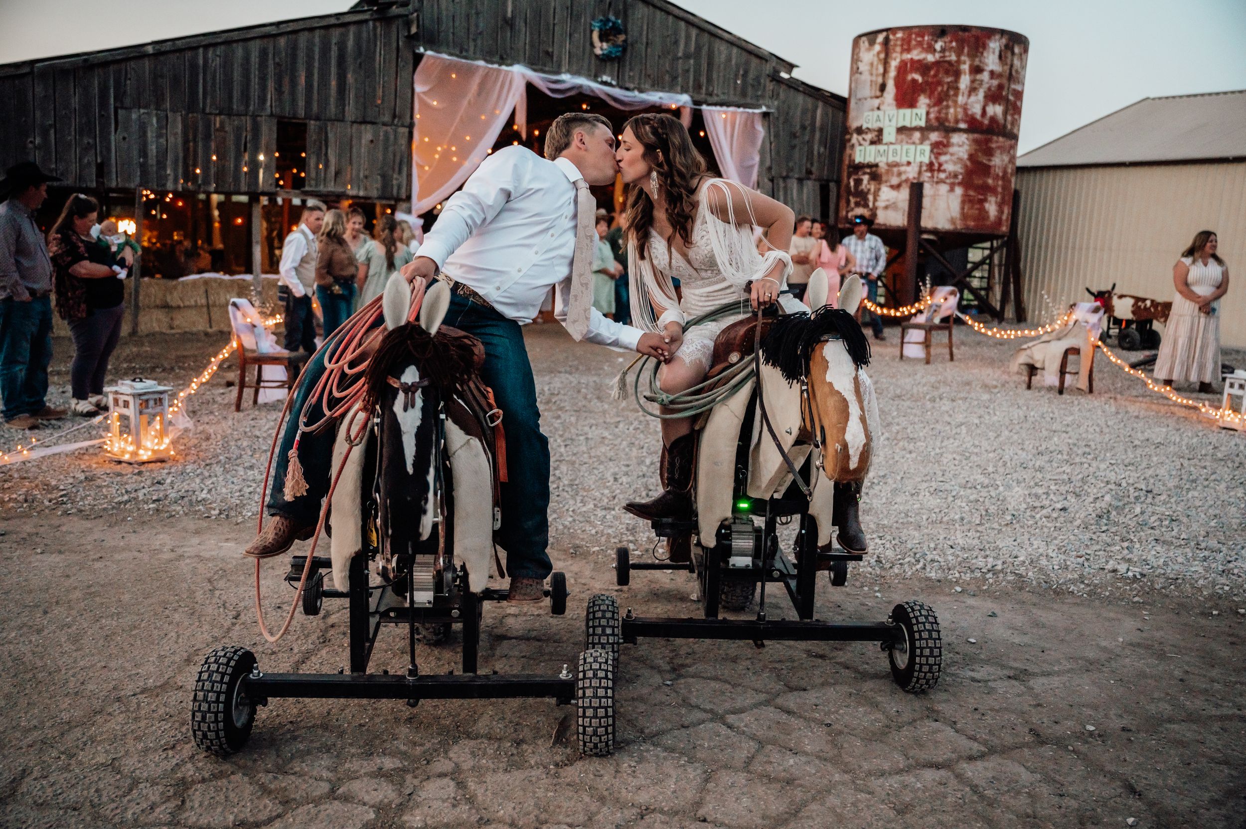 Wedding party gathered outside a rustic barn venue in casual country style.