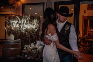 Wedding reception celebration inside a warmly lit venue with dancing and festivities.