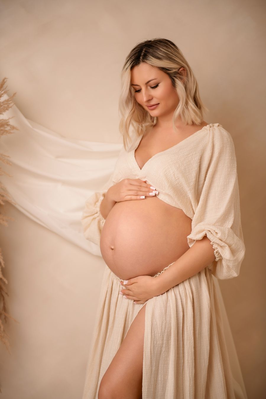 Maternity photo series showing a pregnant mum gently caressing her pregnancy bump.
