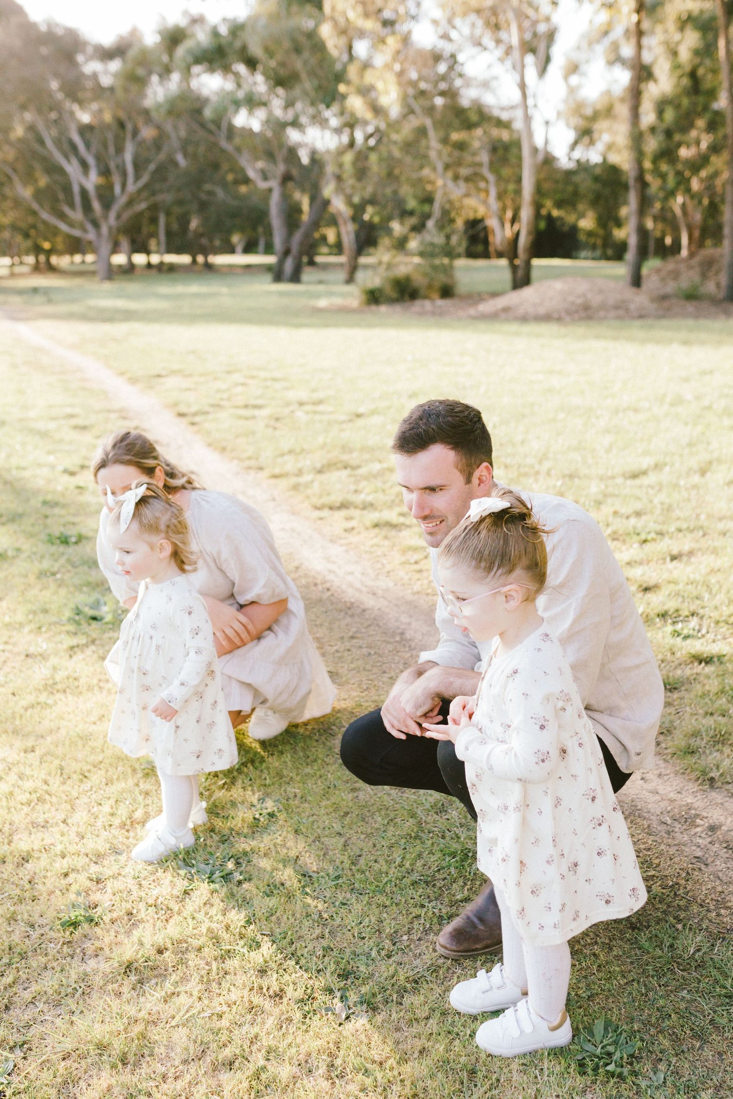 A tender moment shared between figures playing on grassy lawn during golden hour.