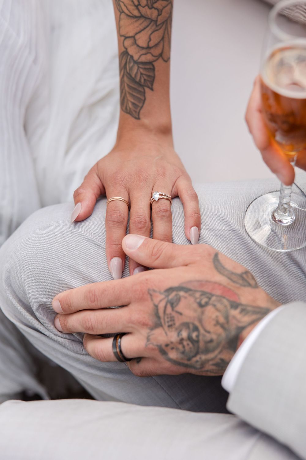 Close-up shots of tattooed hands wearing wedding rings against a white background.