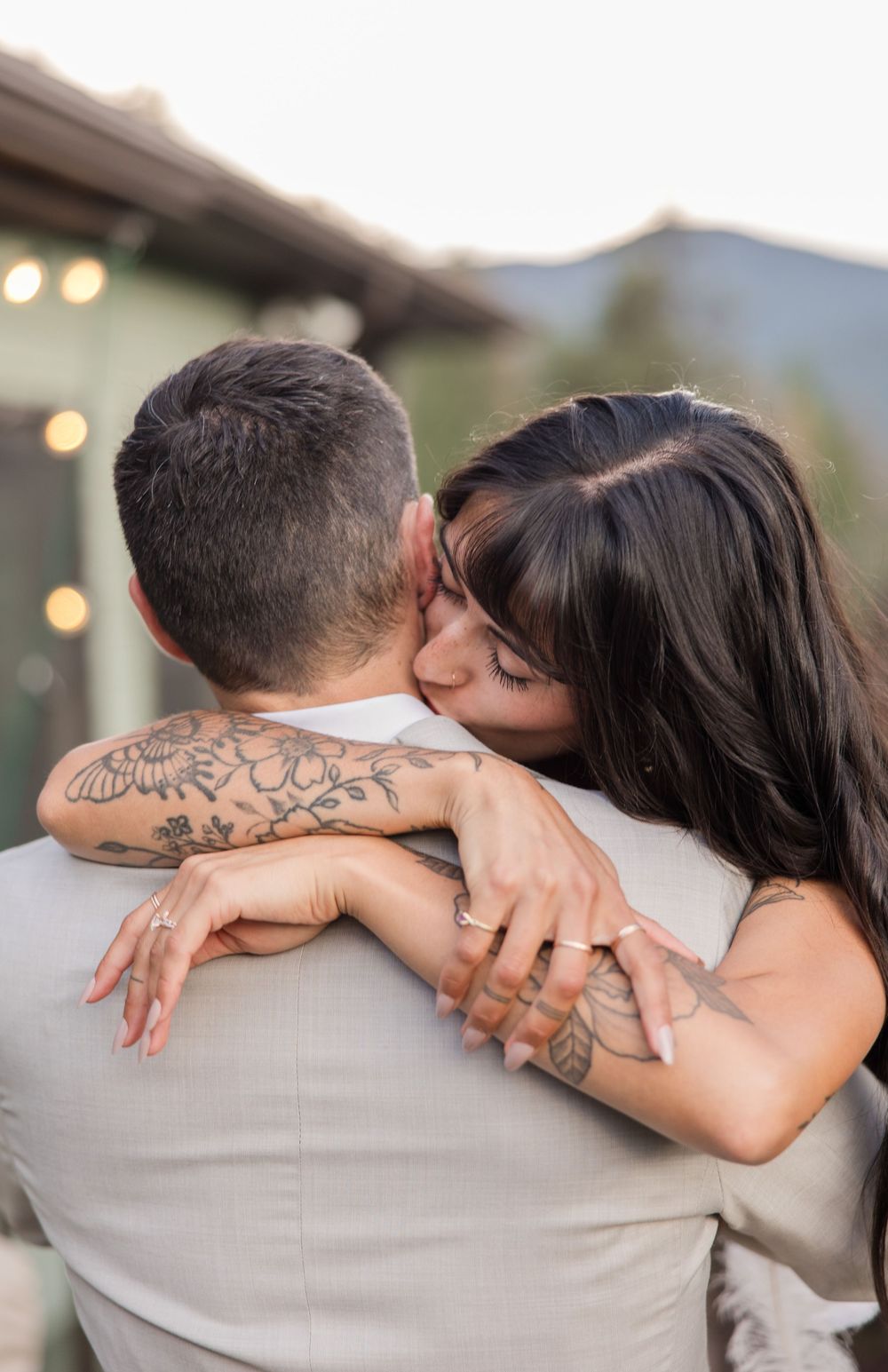 Bride rests on groom's shoulder showing romantic connection in soft natural lighting.