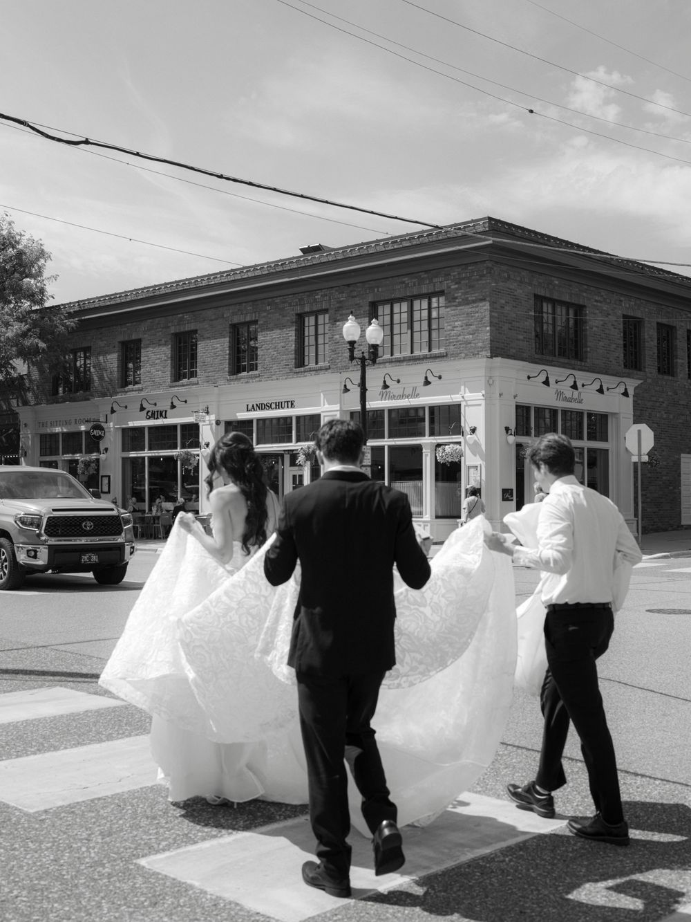 A series of four sequential photos showing a bride's dress billowing dramatically in the wind against a building exterior.