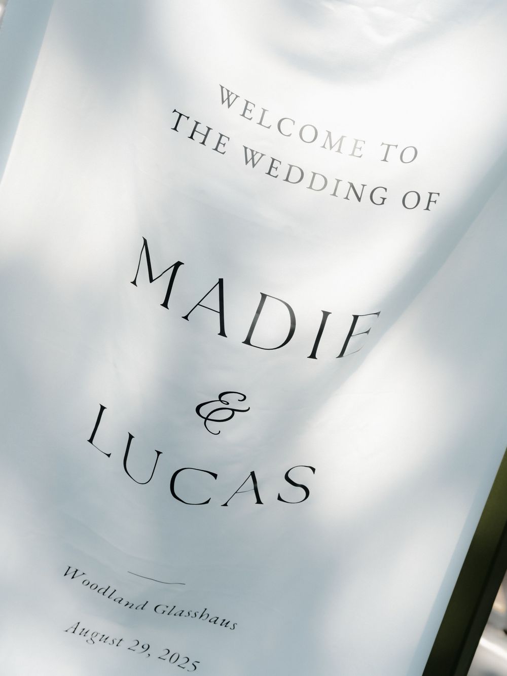 Close up detail of an elegant wedding invitation with stylish typography on a white background.