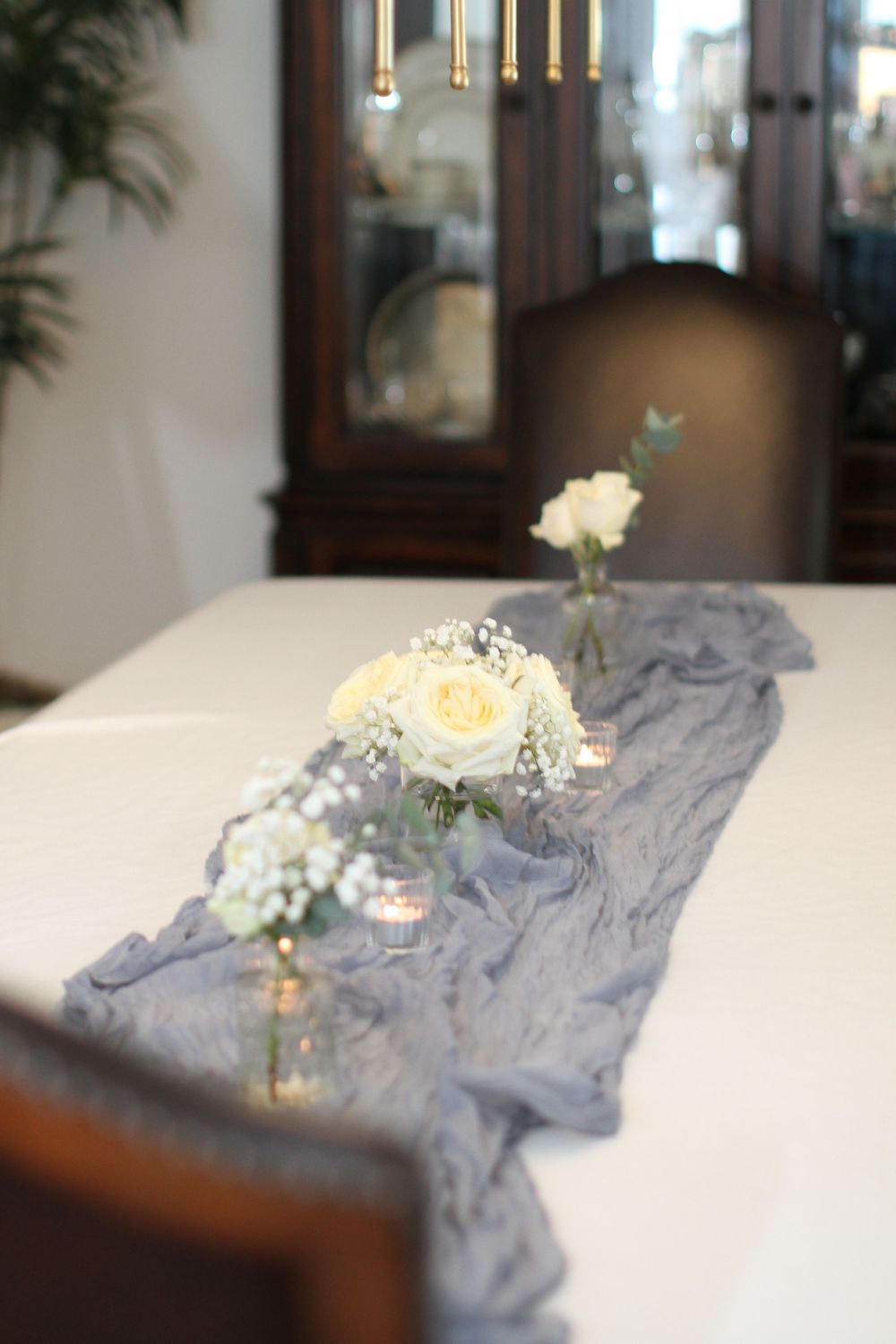 Fresh flowers lying on light blue fabric with soft natural lighting in an interior setting.